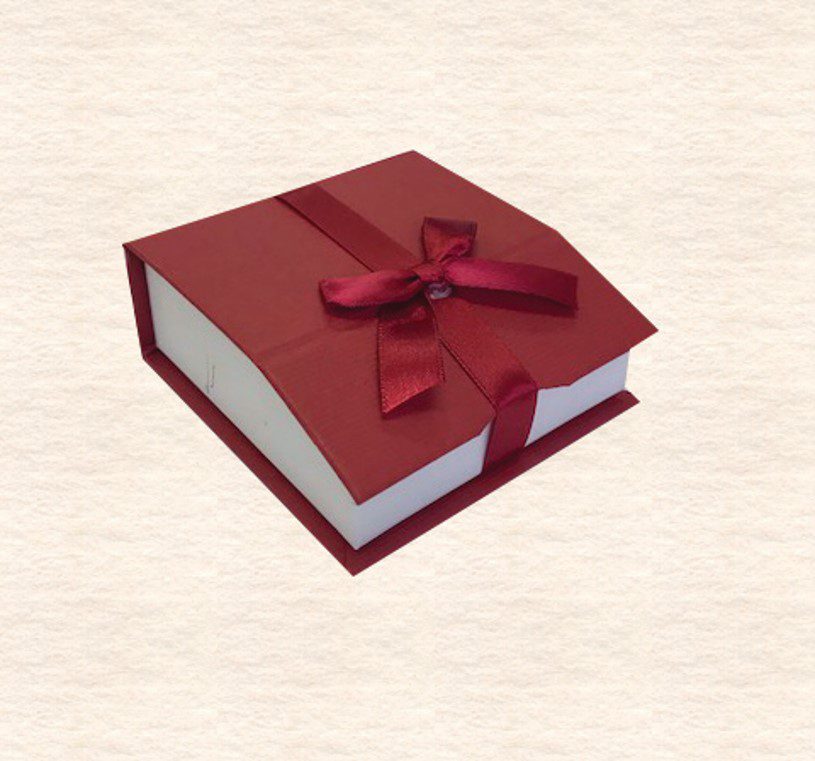 A red book with a bow on top of it.