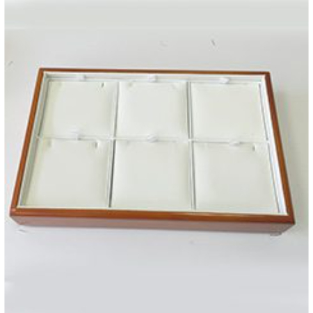 A wooden tray with six white jewelry trays.