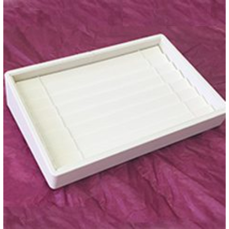 A white tray on top of purple cloth.