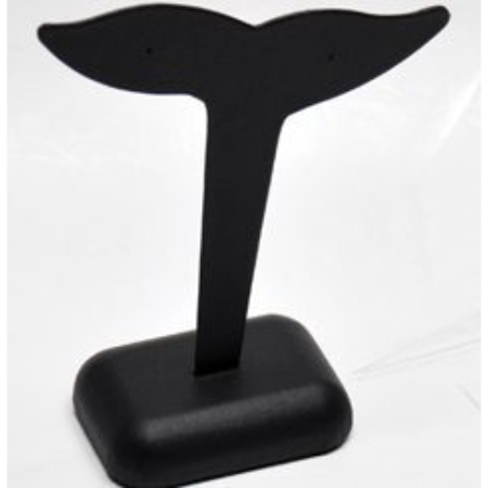 A black plastic whale earring holder on top of a table.