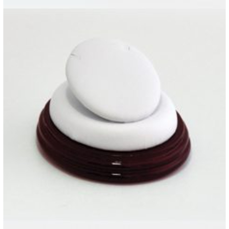 A white object sitting on top of a brown wooden base.