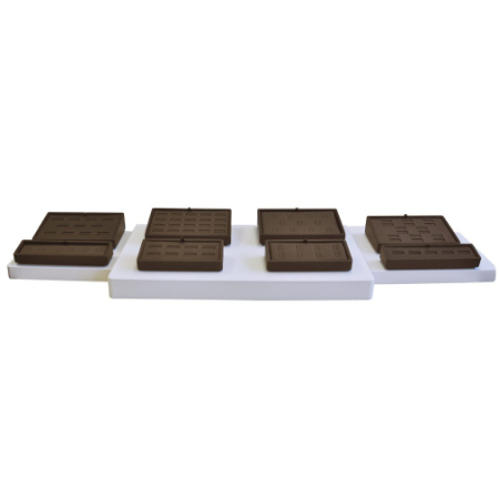 A white tray with chocolate squares on top of it.